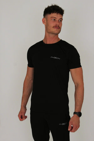 Front view of model wearing Phixion Active T-Shirt in black against a white background. Athletic fit with performance fabric.
