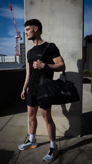 Phixion Gym Holdall worn over the shoulder in an everyday setting. Model displays the bag’s sleek, functional design for active lifestyles.