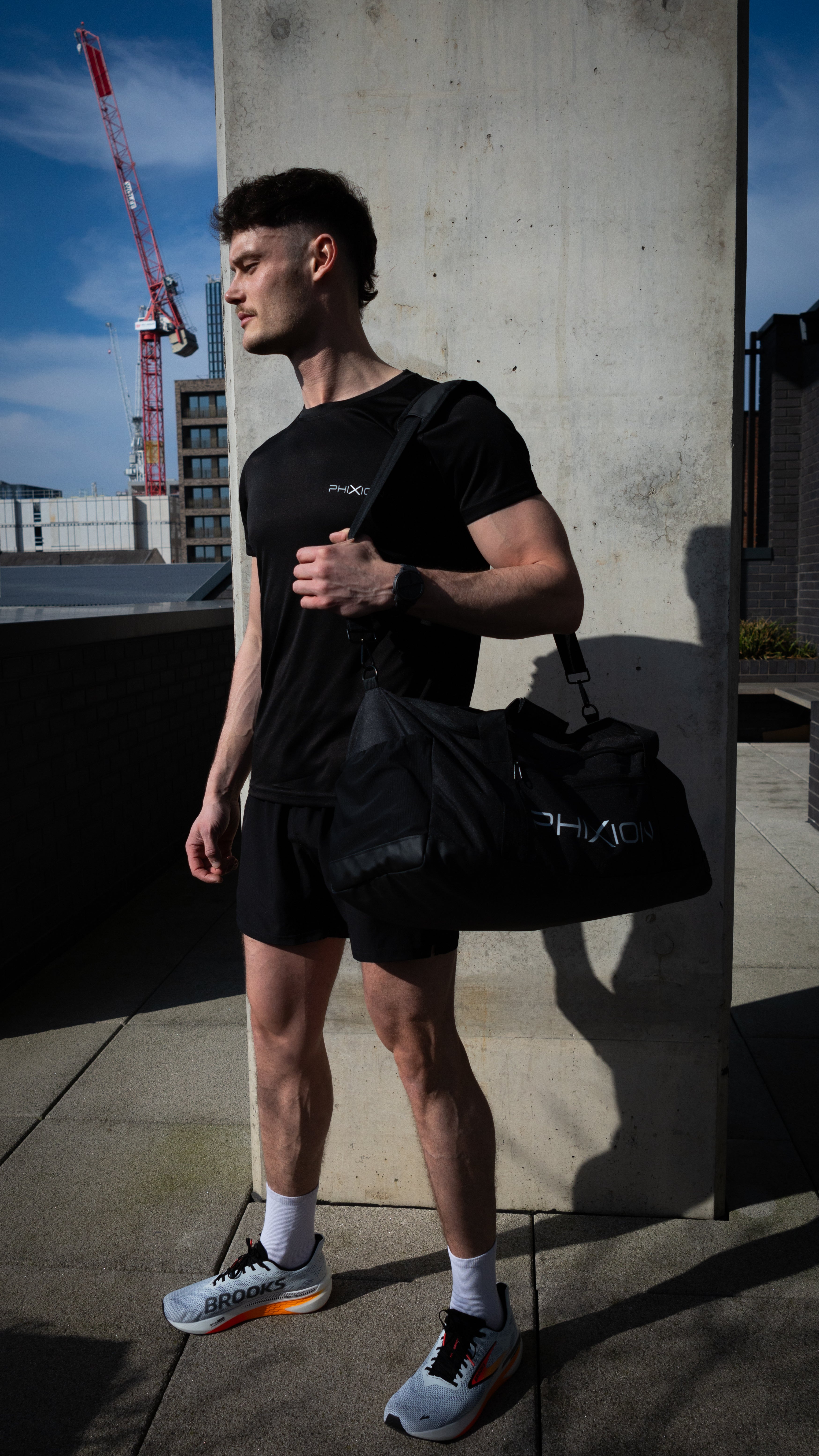 Phixion Gym Holdall worn over the shoulder in an everyday setting. Model displays the bag’s sleek, functional design for active lifestyles.