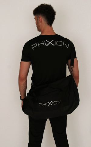 Model wearing Phixion Gym Holdall over one shoulder with back to camera. Styled with Phixion Active T-Shirt, showcasing the full gym-ready look.