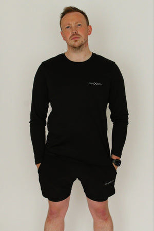 Front view of model wearing Phixion Active Long Sleeve T-Shirt in black against a white background. Sleek athletic fit with lightweight fabric.